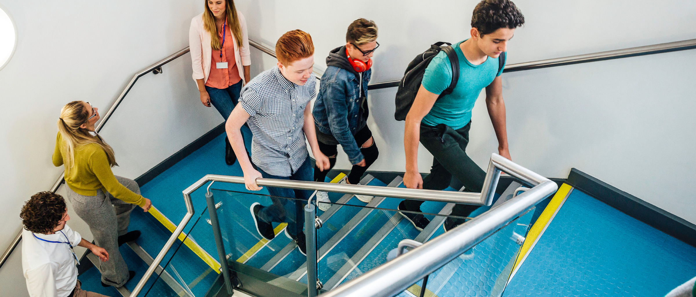 Group of students and teachers walking up a staircase.